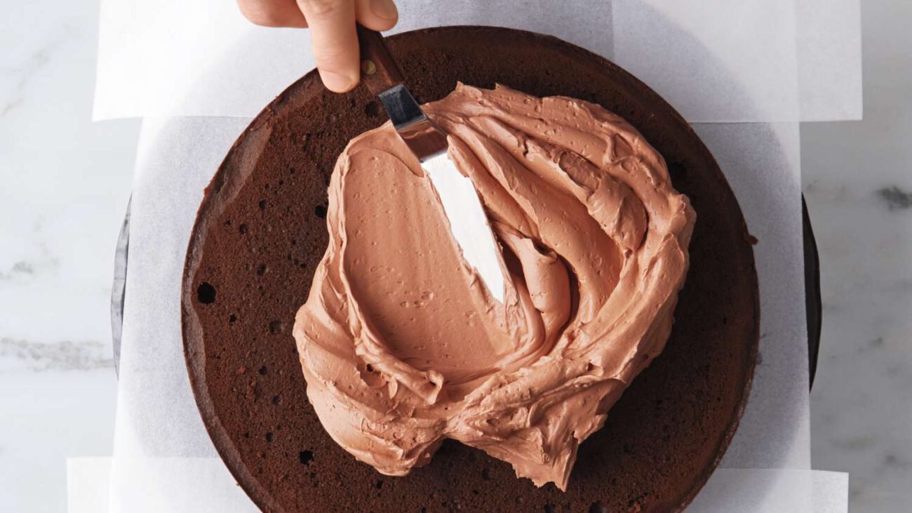 spreading frosting on devils food cake