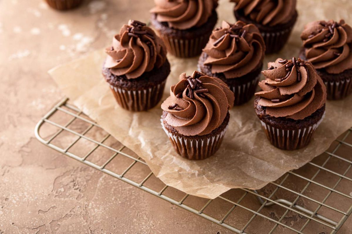 chocolate cupcakes with chocolate frosting on cooling rack