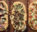 3 different pizzas on grilling planks