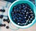 overhead view of washed blueberries in a teal colander