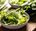torn romaine lettuce in a white bowl on a wooden board