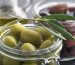 Jars of green and black olives a bottle of olive oil garnished with olive leaves