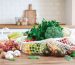 A producefilled mesh bag on a wooden kitchen counter