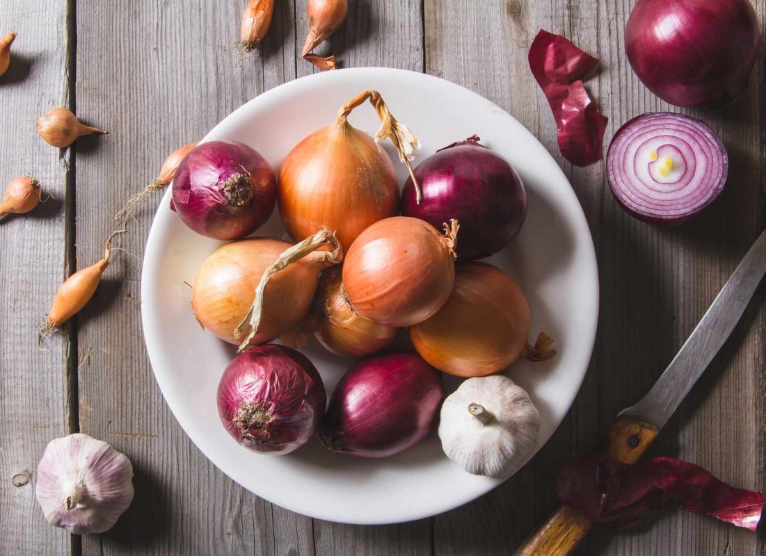 overhead view of bowl of onions and garlic