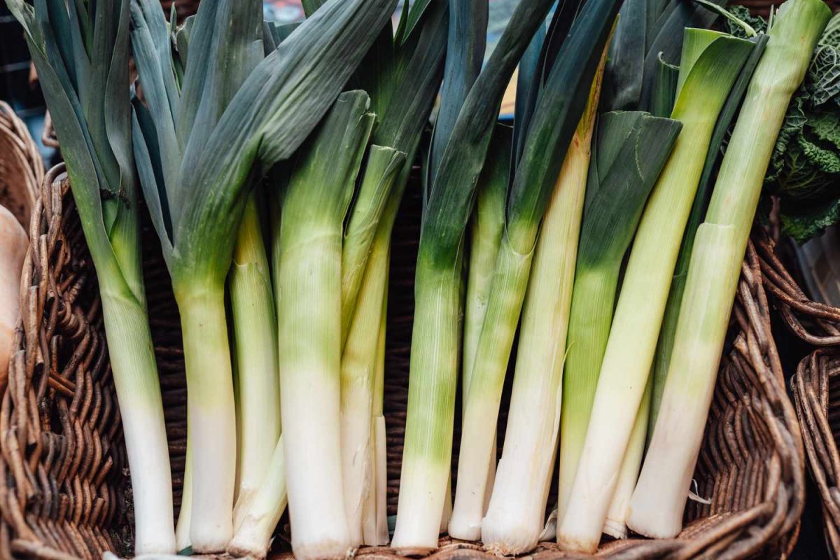 Basket of organic leeks selling in vegetable market. Vegan food and lifestyles. Small business. Economy and inflation.