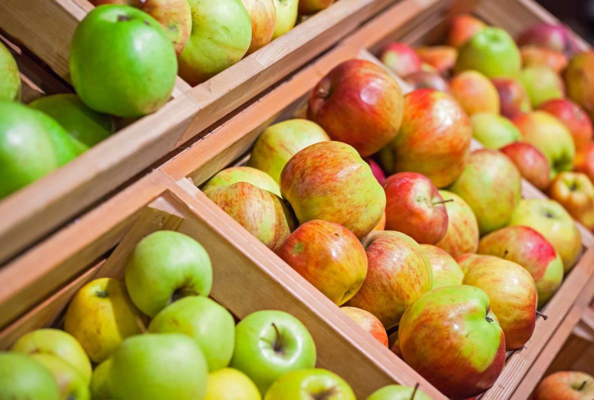 A display of apples arranged in wooden crates at a grocery store