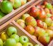 A display of apples arranged in wooden crates at a grocery store